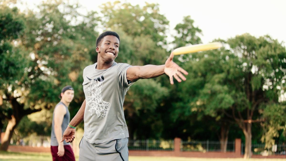 a student throws a frisbee on the intramural field